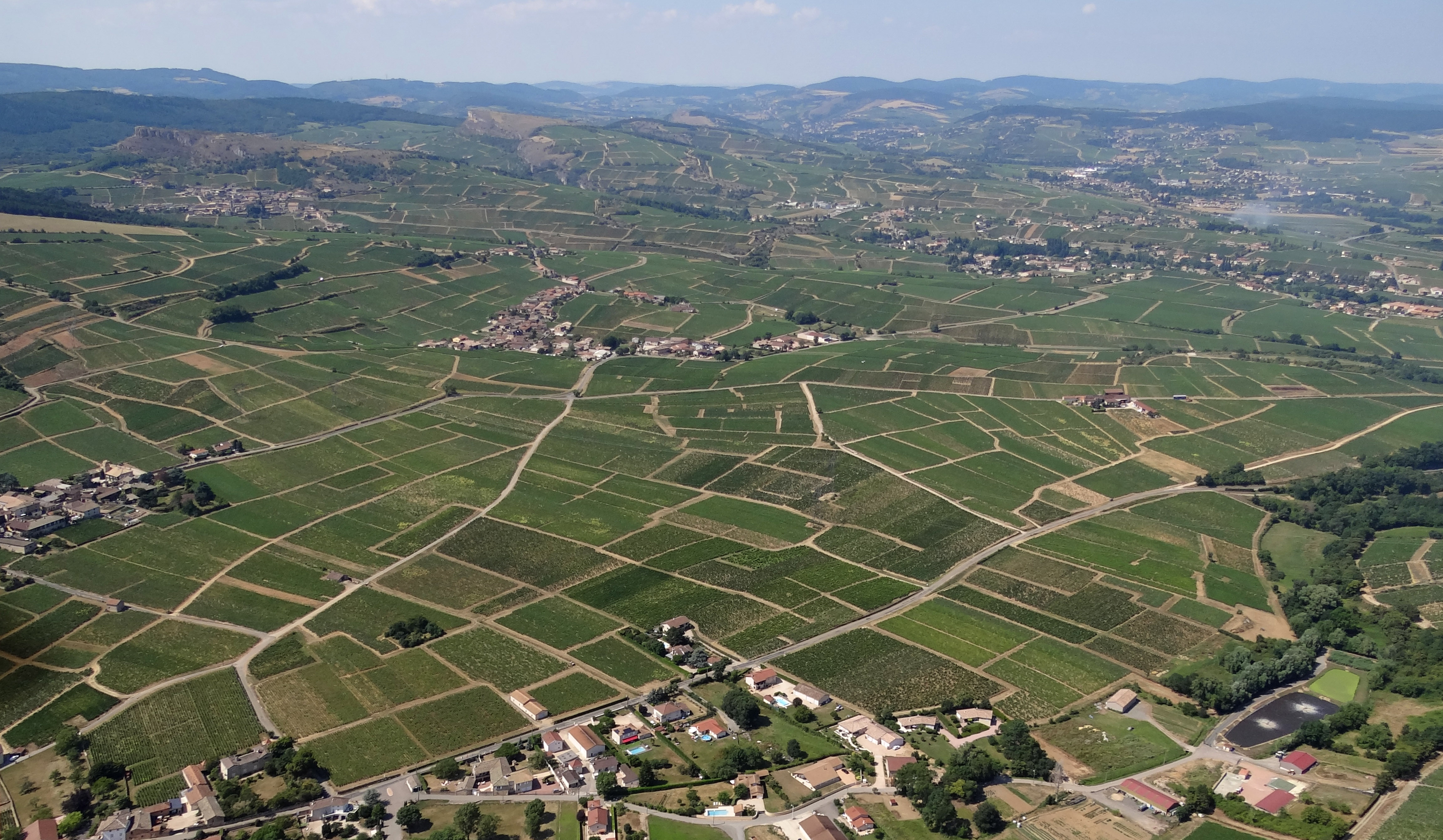 Au sud de la vallée de la Petite Grosne, le vignoble devient prépondérant sur les versants dominant la vallée de la Saône. Fuissé au premier plan, Pouilly en second plan. en grand format (nouvelle fenêtre)