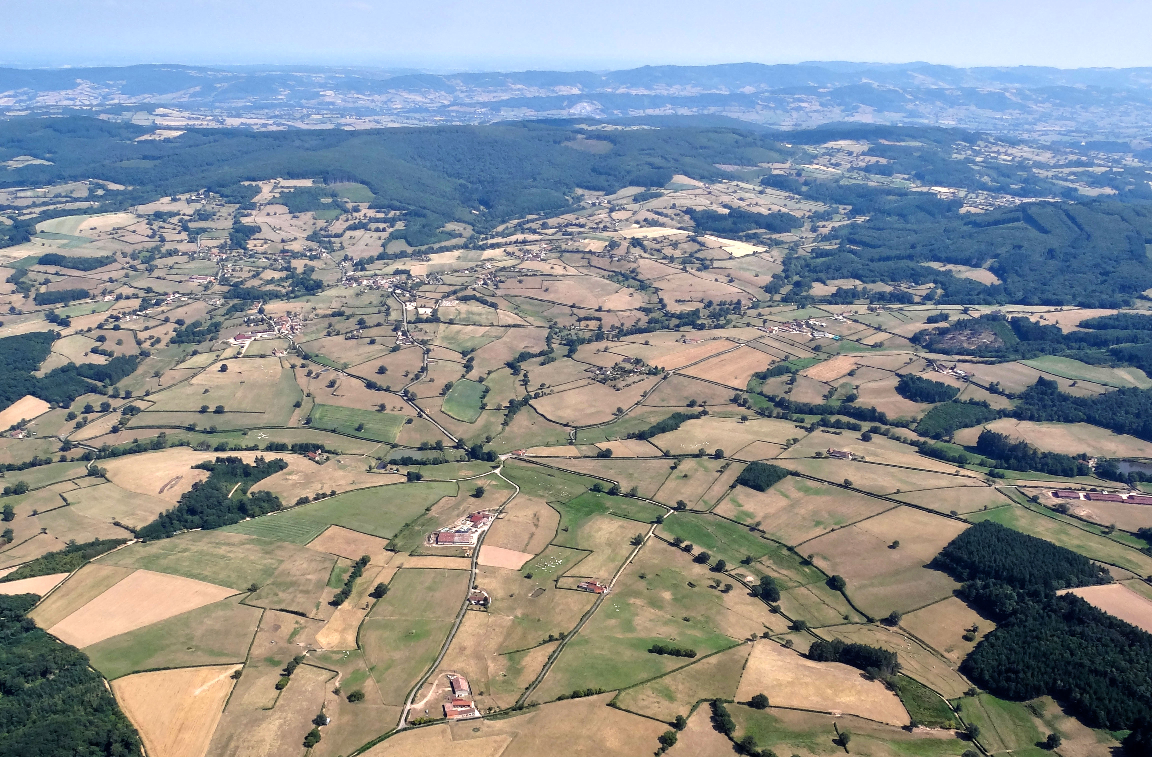 La Gande et ses nombreux affluents, ouvrent un vaste éventail (bassin de Donzy-le-National), dont les reliefs adoucis s’adossent à une crête forestière affirmée, ponctuée de monts élevés (Butte de Suin à 600m, Ste-Colombe à 501 m, Laurandon à 512m. Au premier plan les fermes du Champ Matron et du Clous Cortot, en arrière-plan le village de Buffières.