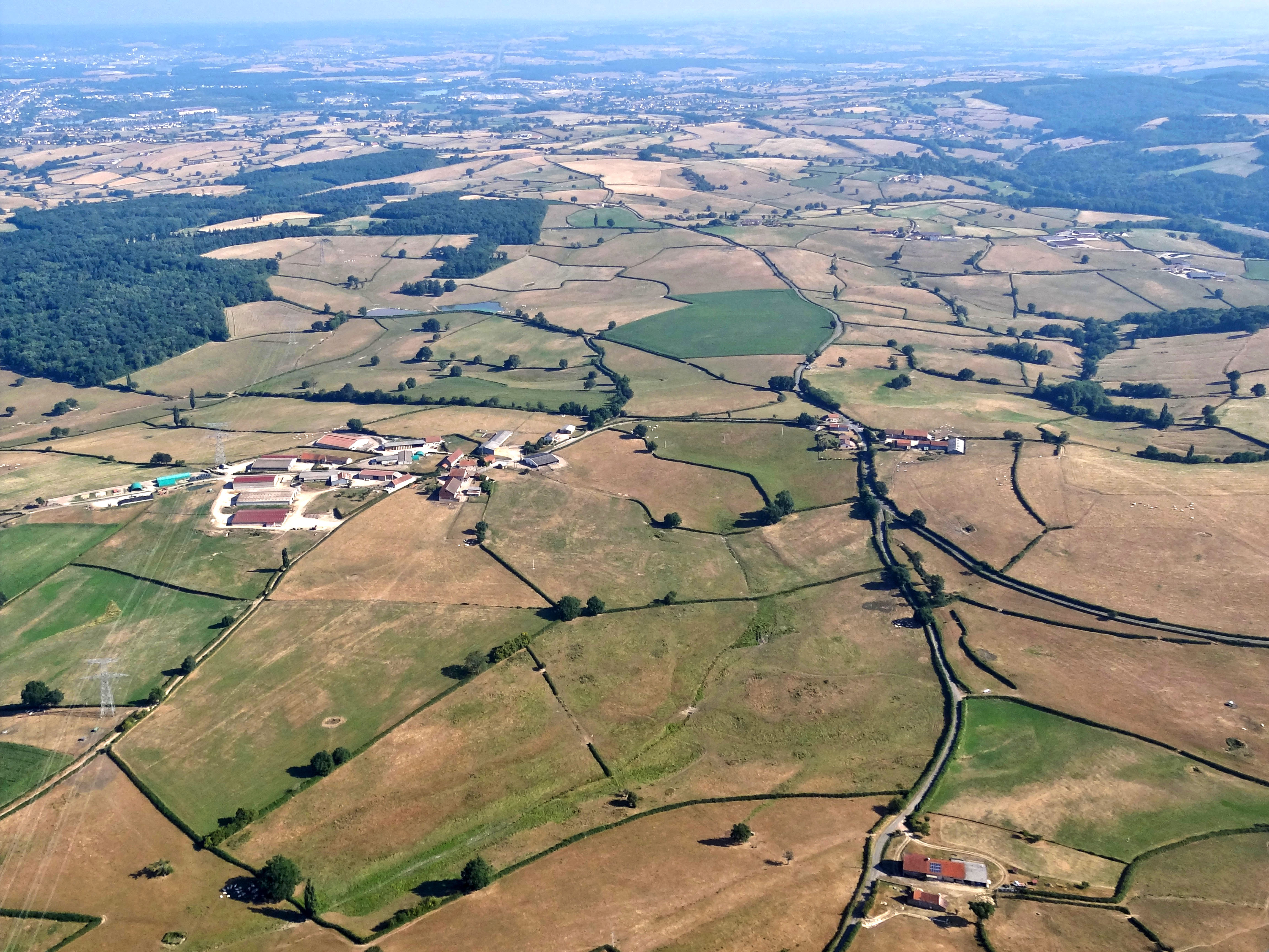 Le Charolais présente un relief assez homogène, formé de collines à larges ondulations dont les altitudes moyennes sont comprises entre 250 et 350 m. Au premier plan la ferme des Mouilles, au second plan les fermes de Dieulegard et de Noiseret sur la commune de St-Micaud.