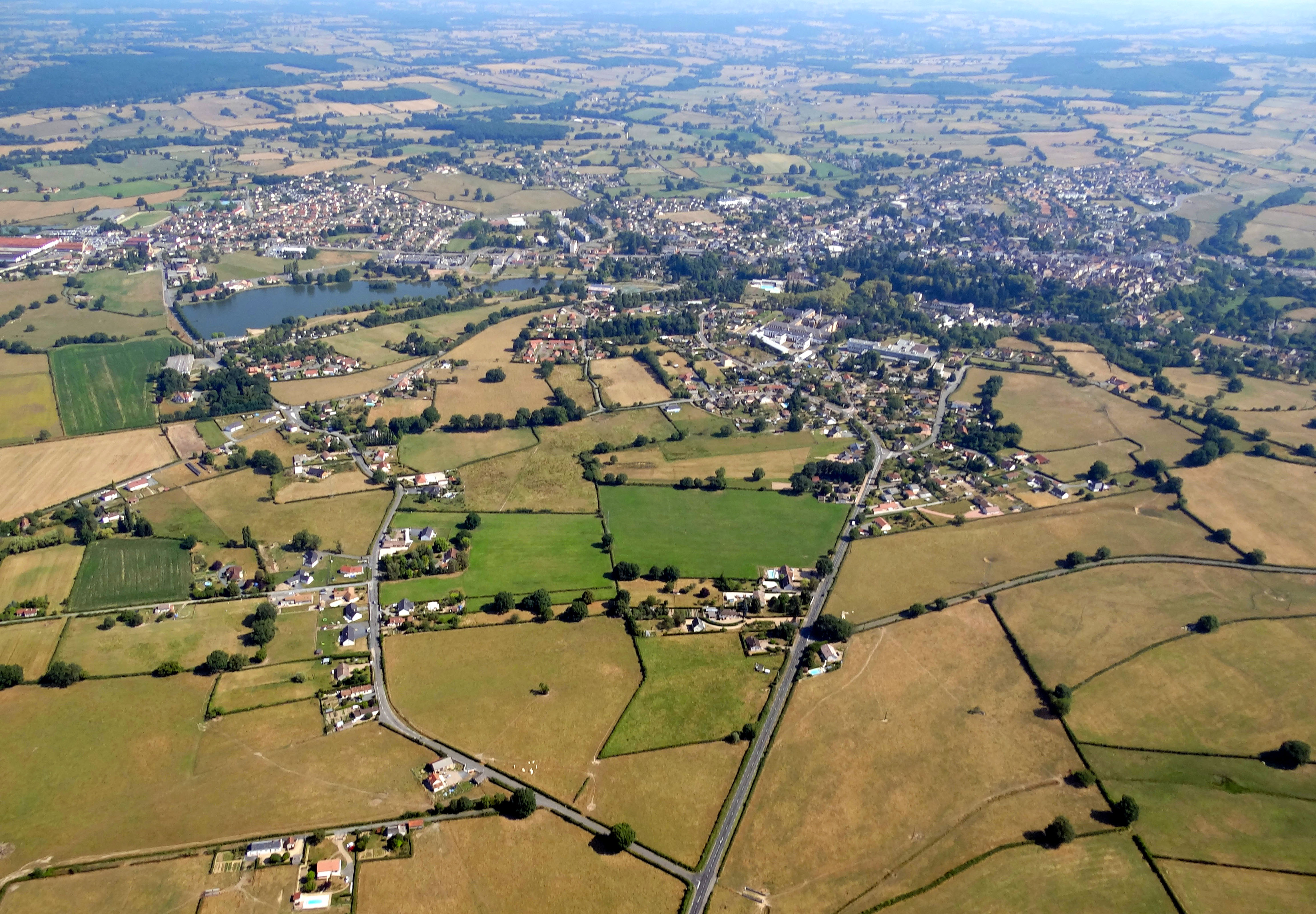 Bourbon-Lancy avec 5200 habitants est la ville principale du Bourbonnais. Le bourg médiéval implanté sur un léger éperon est aujourd’hui largement entouré par des extensions qui ont dilaté sa silhouette et brouillent la lisibilité du site originel. Au premier plan le bâti diffuse le long des routes. En arrière-plan on peut distinguer le quartier thermal au pied du coteau boisé, à gauche le plan d’eau du Breuil.