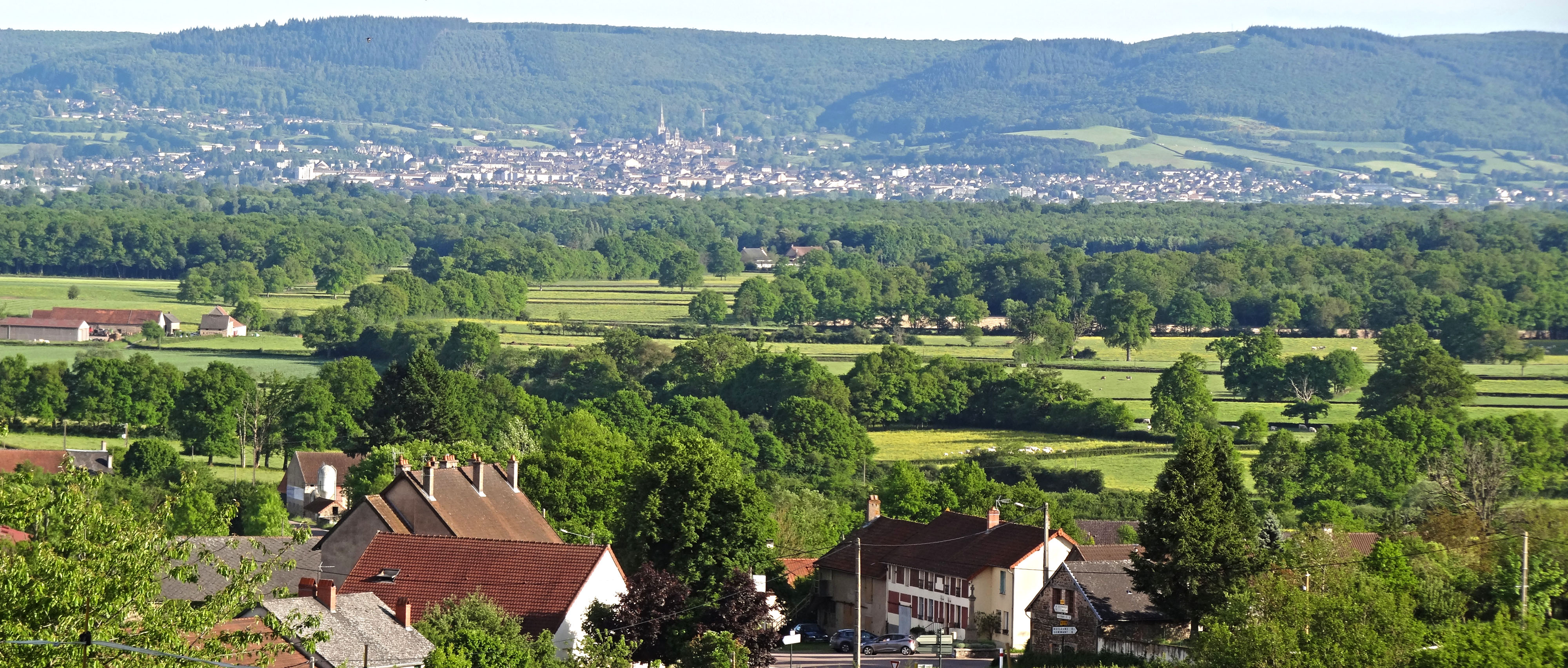 Entre les reliefs boisés de la Montagne Autunoise et du Morvan, la plaine d'Autun forme une vaste dépression bocagère dominée par la silhouette de la ville d'Autun. Vue depuis les contreforts du Morvan à Reclesne 